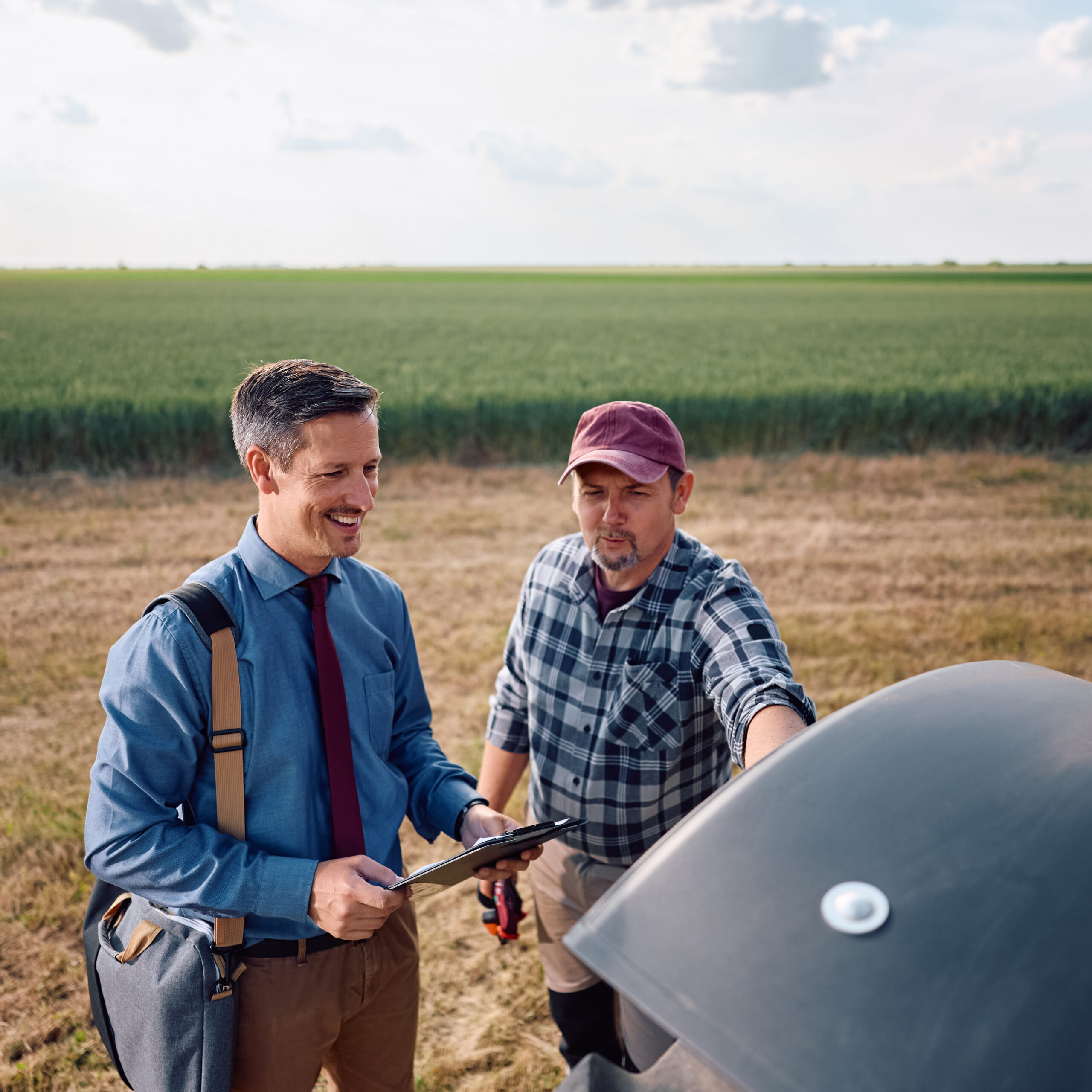 Happy Insurance Agent And Agricultural Business Owner In Field.